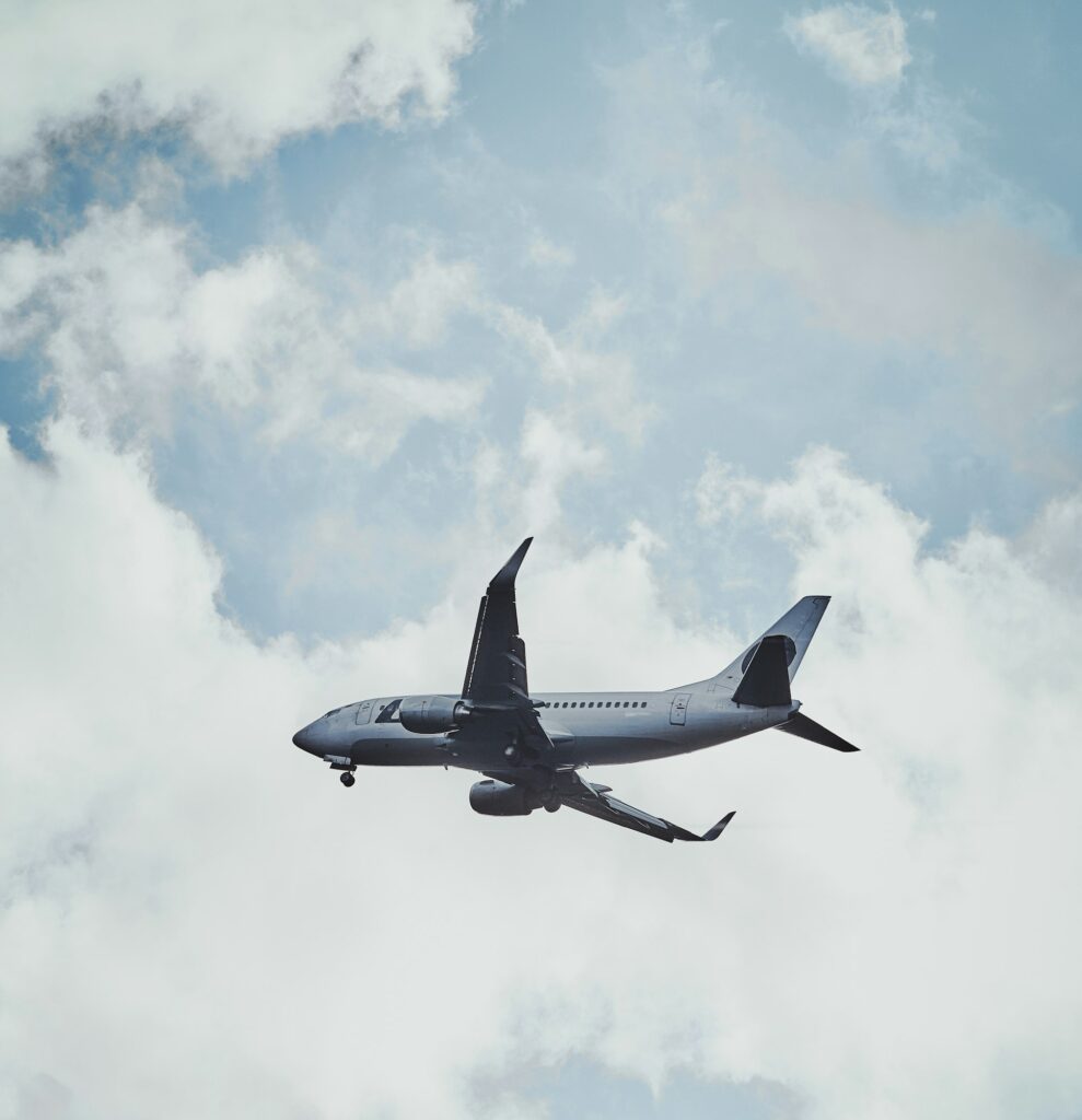 Plane in the cloudy sky is flying from aeroport after rain.